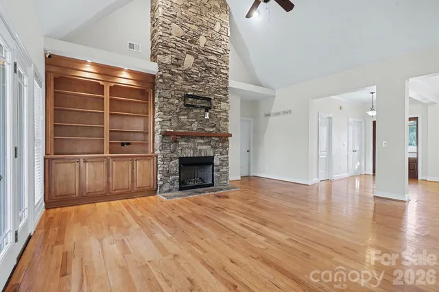 a view of empty room with wooden floor and fireplace