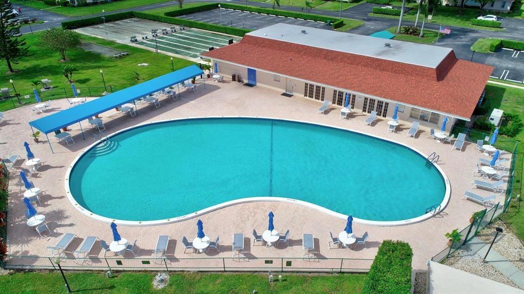 5245 Northwest 3rd Street, Unit D Delray Beach, FL 33445 - Photo 13 of 18 a view of a swimming pool with a yard