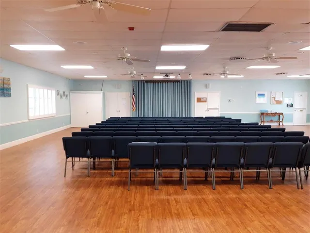 a living room with furniture a wooden floor and kitchen view