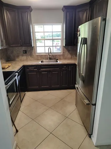 a kitchen with granite countertop a refrigerator and a sink