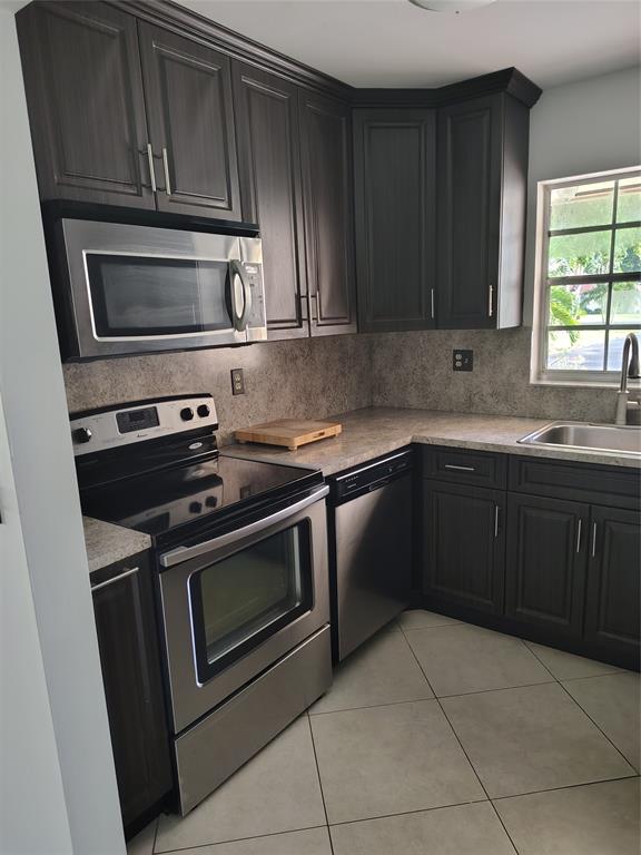 5245 Northwest 3rd Street, Unit D Delray Beach, FL 33445 - Photo 5 of 18 a kitchen with a stove sink and microwave