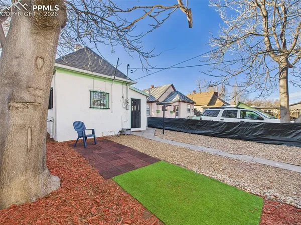 a front view of a house with a yard and potted plants