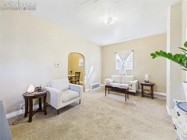 a living room with furniture and a potted plant