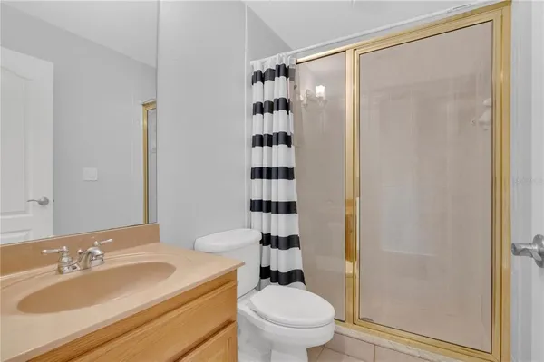 a bathroom with a sink a toilet a shower and a mirror