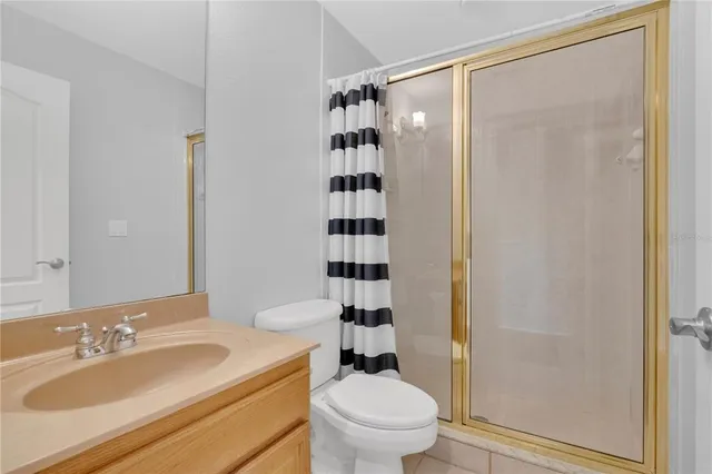 a bathroom with a sink a toilet a shower and a mirror