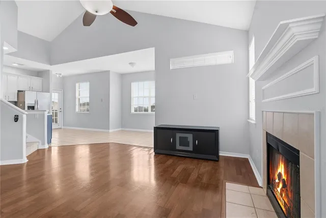a view of a livingroom with wooden floor and a fireplace