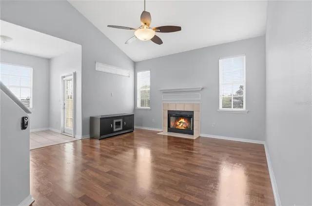 an empty room with wooden floor a fireplace and a window
