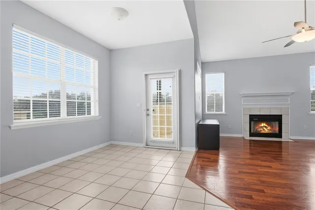 a view of an empty room with glass door and wooden floor