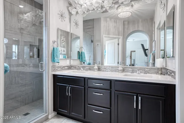 a bathroom with a granite countertop sink a large mirror and a shower