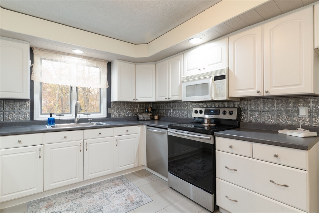 15 Cherokee Road Holland, MA 01521 - Photo 10 of 42 a kitchen with granite countertop white cabinets white appliances and a sink