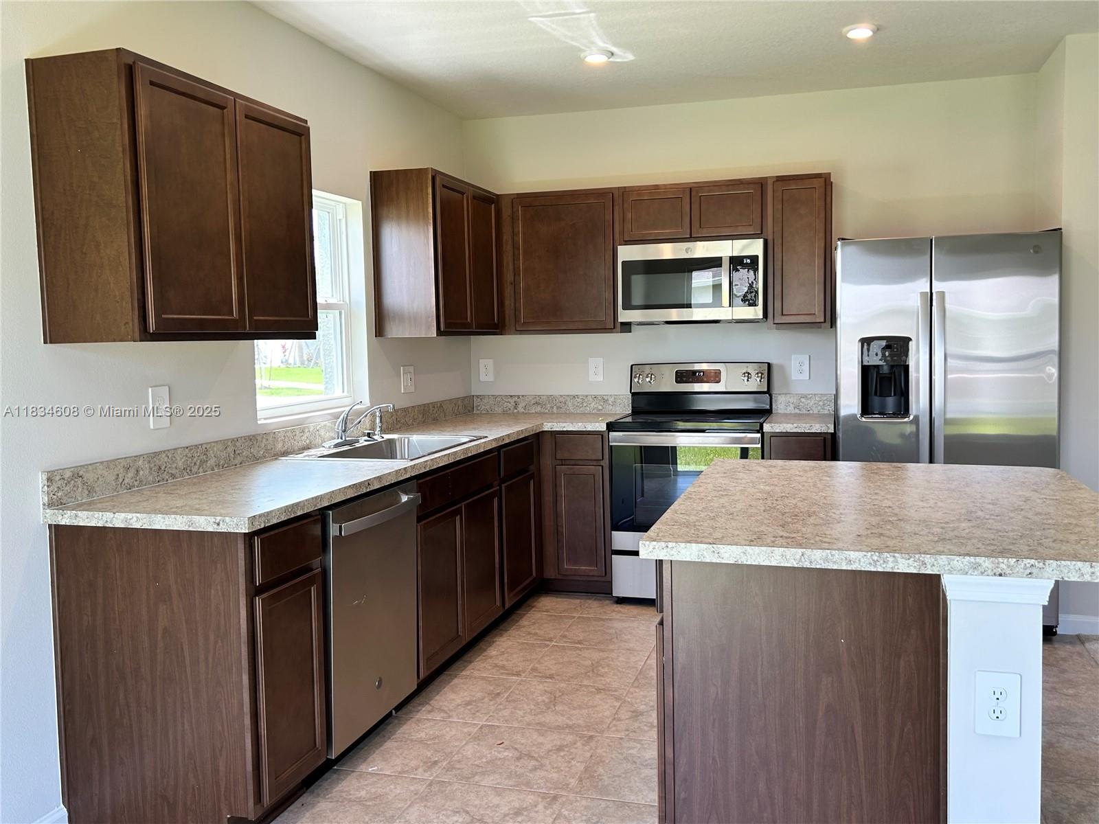217 Raspberry Road Fort Pierce, FL 34981 - Photo 17 of 39 a kitchen with stainless steel appliances granite countertop a sink stove and refrigerator