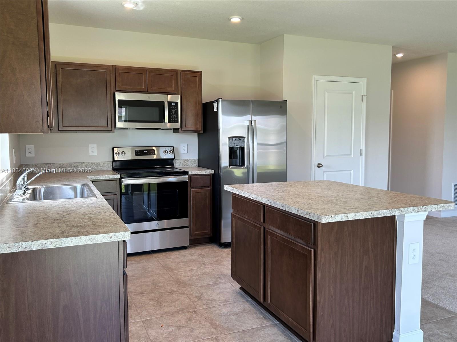 217 Raspberry Road Fort Pierce, FL 34981 - Photo 18 of 39 a kitchen with kitchen island a sink appliances and cabinets
