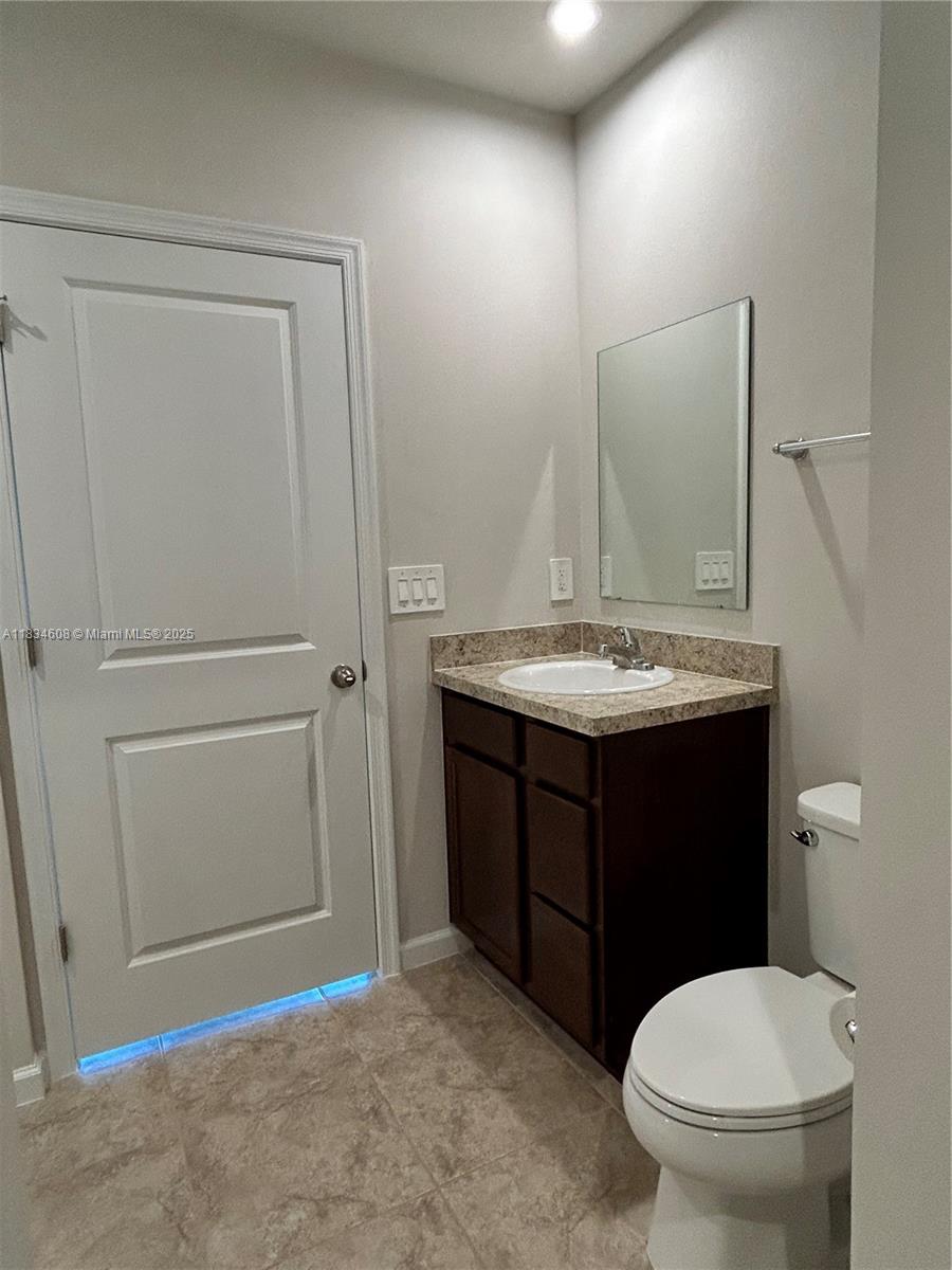 217 Raspberry Road Fort Pierce, FL 34981 - Photo 23 of 39 a bathroom with a granite countertop toilet sink and mirror