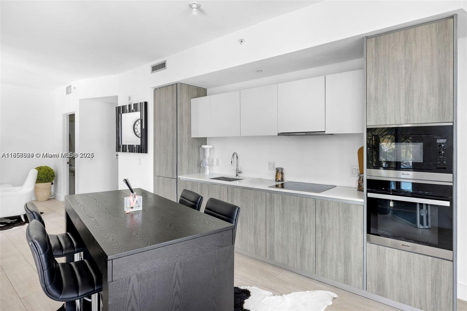 2900 Northeast 7th Avenue, Unit 809 Miami, FL 33137 - Photo 6 of 33 a kitchen with a sink a stove and chairs
