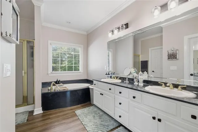 a spacious bathroom with a double vanity sink large mirror and a bathtub
