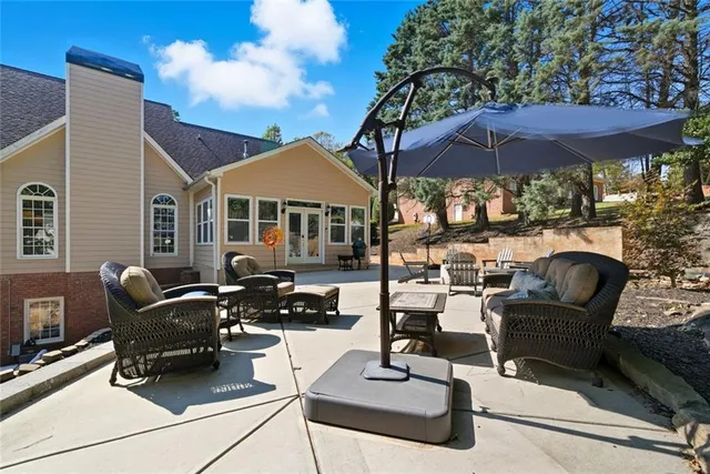 a view of a patio with chairs under an umbrella