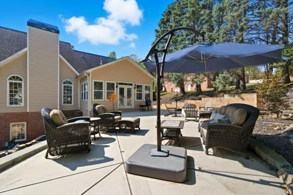 a view of a patio with chairs under an umbrella