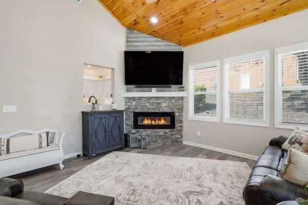 a living room with furniture a flat screen tv and a fireplace