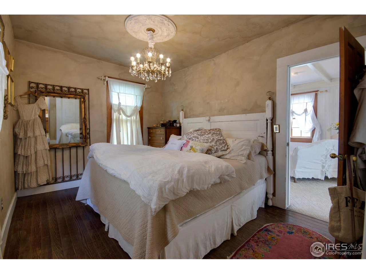406 East Baseline Road Lafayette, CO 80026 - Photo 13 of 24 a spacious bedroom with a bed mirror and a wooden floor