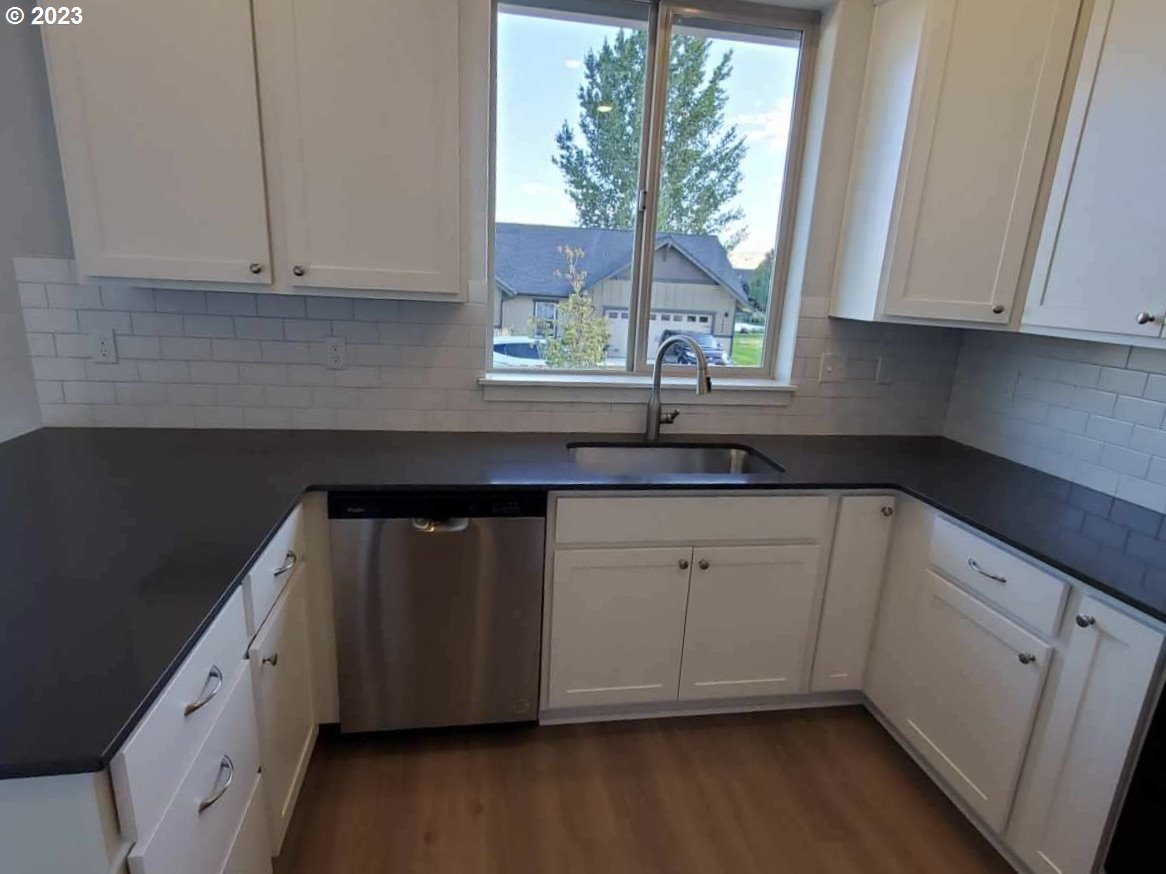 1435 Fish Tail Road Maupin, OR 97037 - Photo 7 of 31 a kitchen with granite countertop white cabinets white appliances a sink and wooden floor