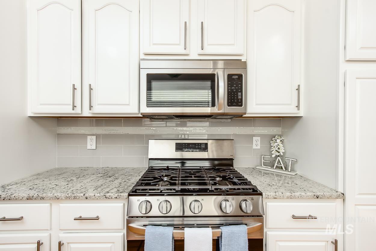 5674 North Heathrow Way Boise, ID 83713 - Photo 11 of 41 Stainless steel range with an over-the-range microwave, set against a subway tile backsplash