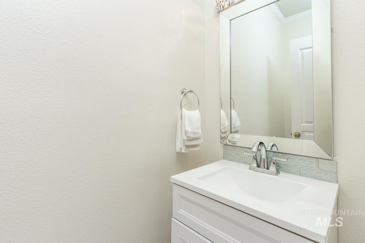 5674 North Heathrow Way Boise, ID 83713 - Photo 14 of 41 Contemporary vanity featuring an integrated sink, polished chrome faucet, and a subway tile backsplash