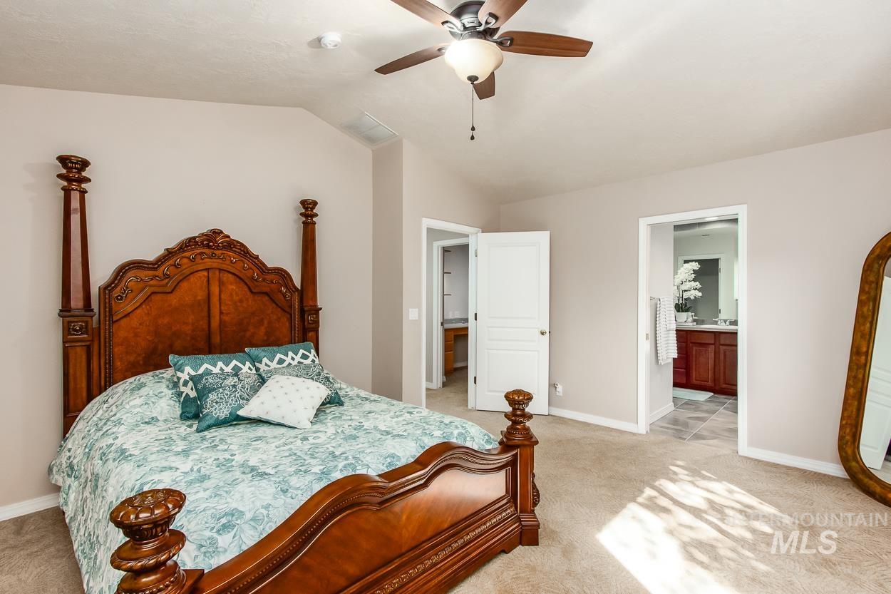 5674 North Heathrow Way Boise, ID 83713 - Photo 24 of 41 Carpeted bedroom featuring a ceiling fan with light fixture, neutral wall paint, and two separate door frames revealing additional interior spaces