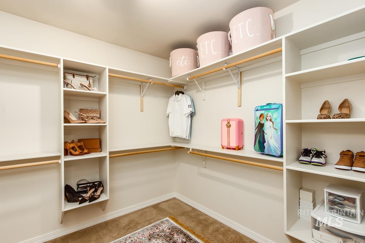 5674 North Heathrow Way Boise, ID 83713 - Photo 26 of 41 Spacious closet featuring built-in shelving, multiple hanging rods, and carpet flooring