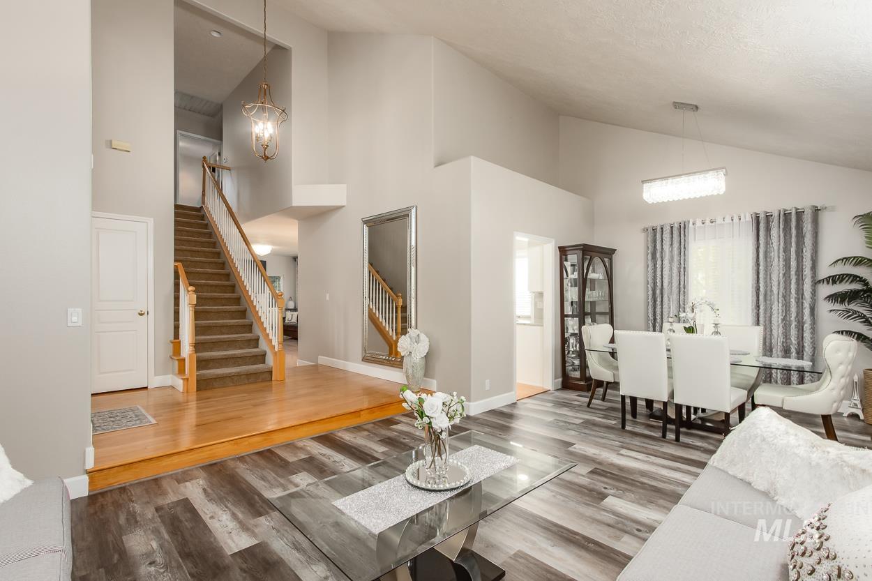 5674 North Heathrow Way Boise, ID 83713 - Photo 6 of 41 Vaulted ceilings enhance this open-concept living space, featuring wood-finish flooring in the main area and hardwood flooring at the staircase landing
