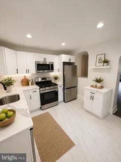 a kitchen with sink a microwave and refrigerator