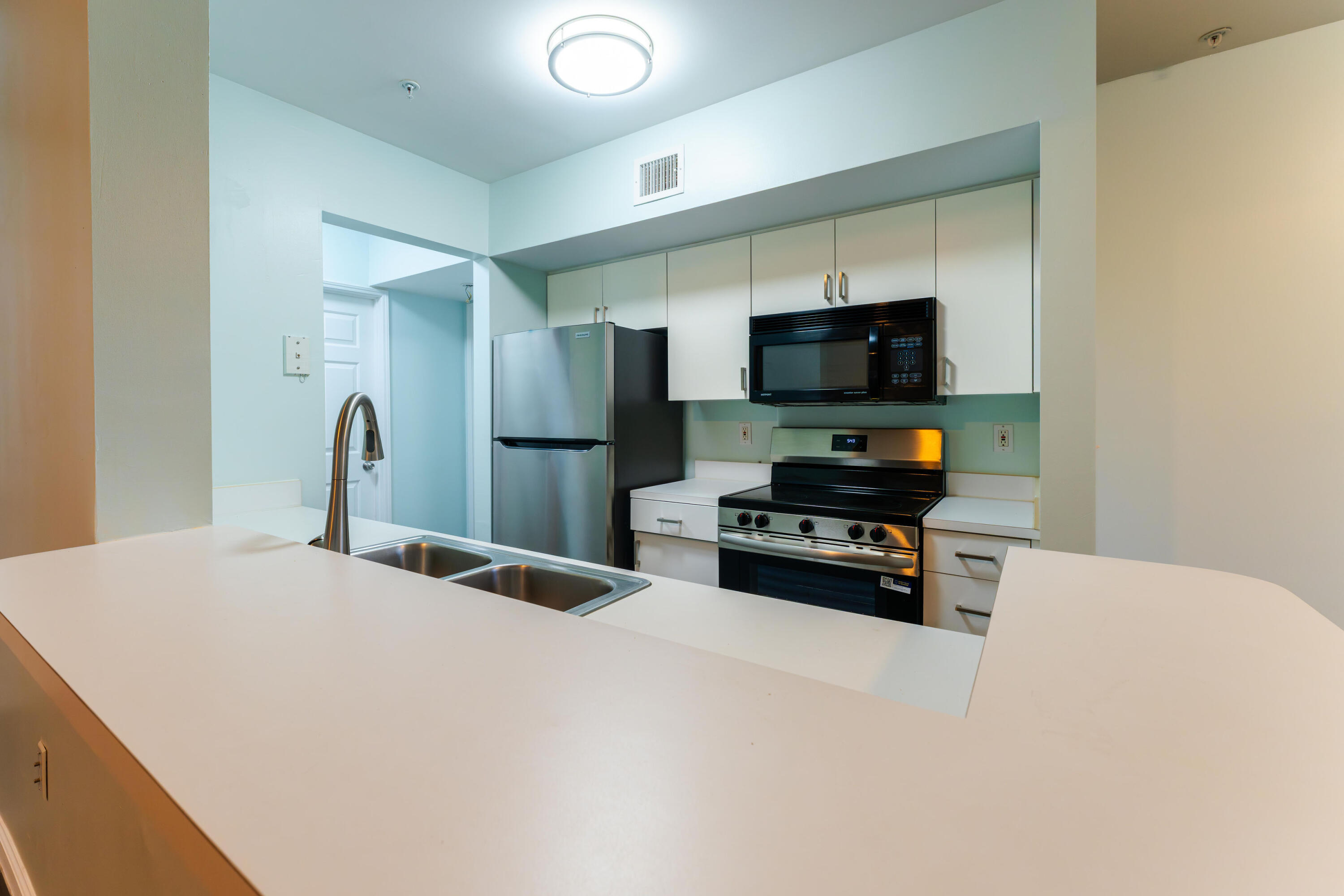 236 Village Boulevard, Unit 1304 Tequesta, FL 33469 - Photo 13 of 30 a kitchen with stainless steel appliances a refrigerator and a stove top oven