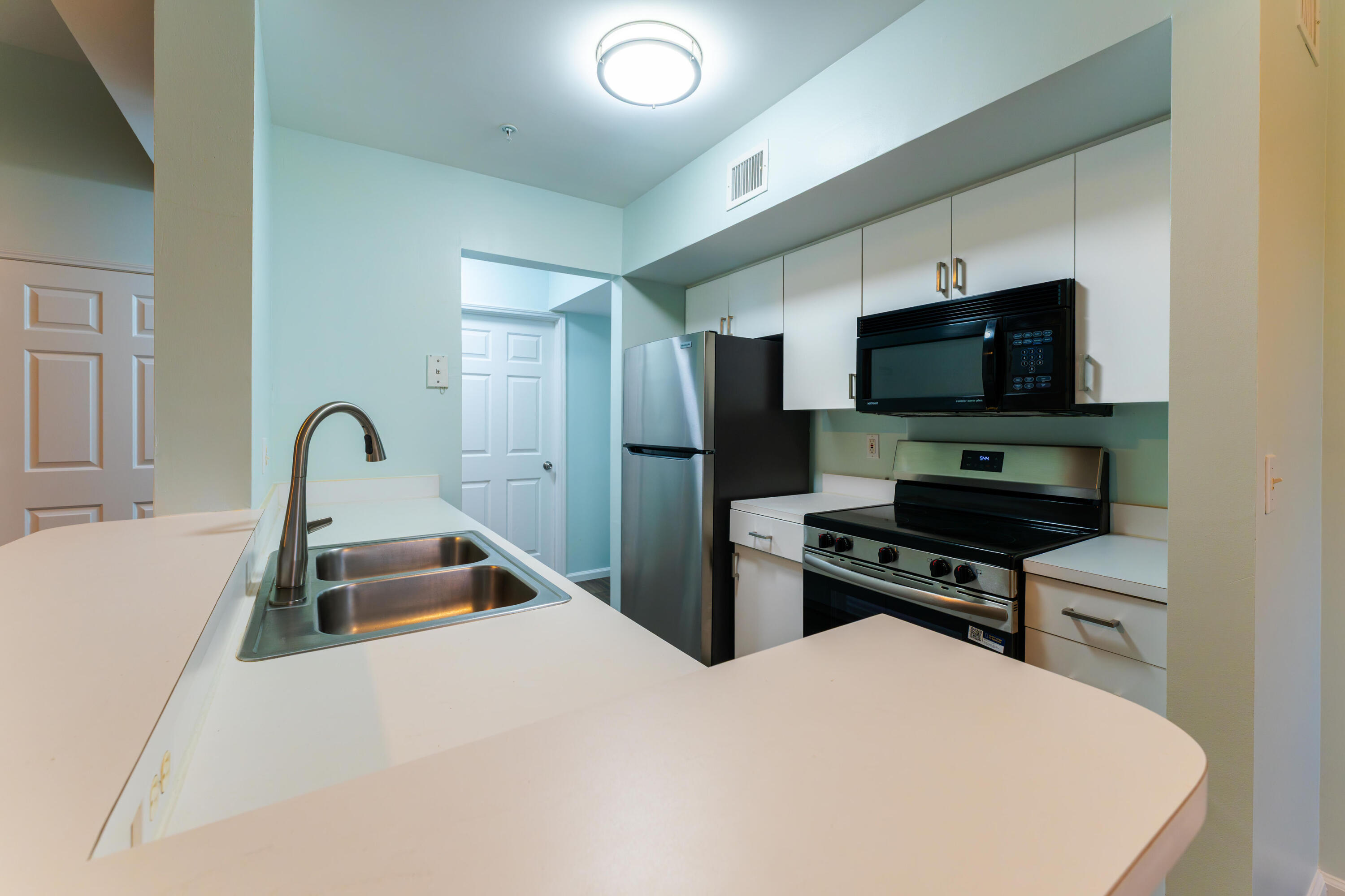 236 Village Boulevard, Unit 1304 Tequesta, FL 33469 - Photo 26 of 30 a kitchen with stainless steel appliances a stove a sink and a refrigerator