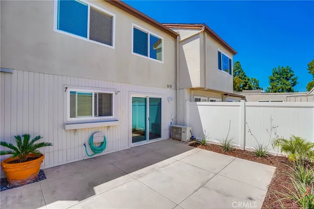 a view of backyard with potted plants and wooden fence