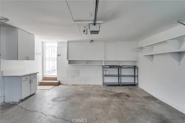a view of a kitchen with a sink and dishwasher a refrigerator with white cabinets
