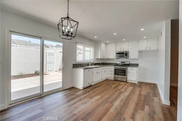 a kitchen with a refrigerator window and white wooden cabinets