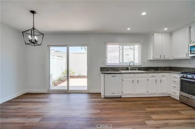 a view of a kitchen with a sink dishwasher and wooden floor