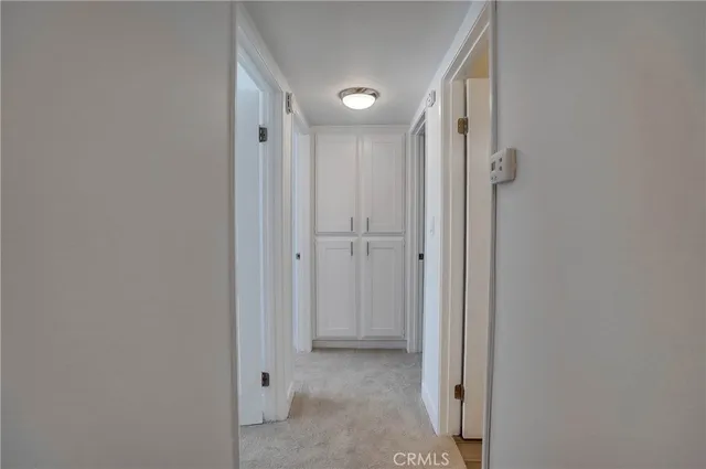 a view of a hallway with closet and a bathroom