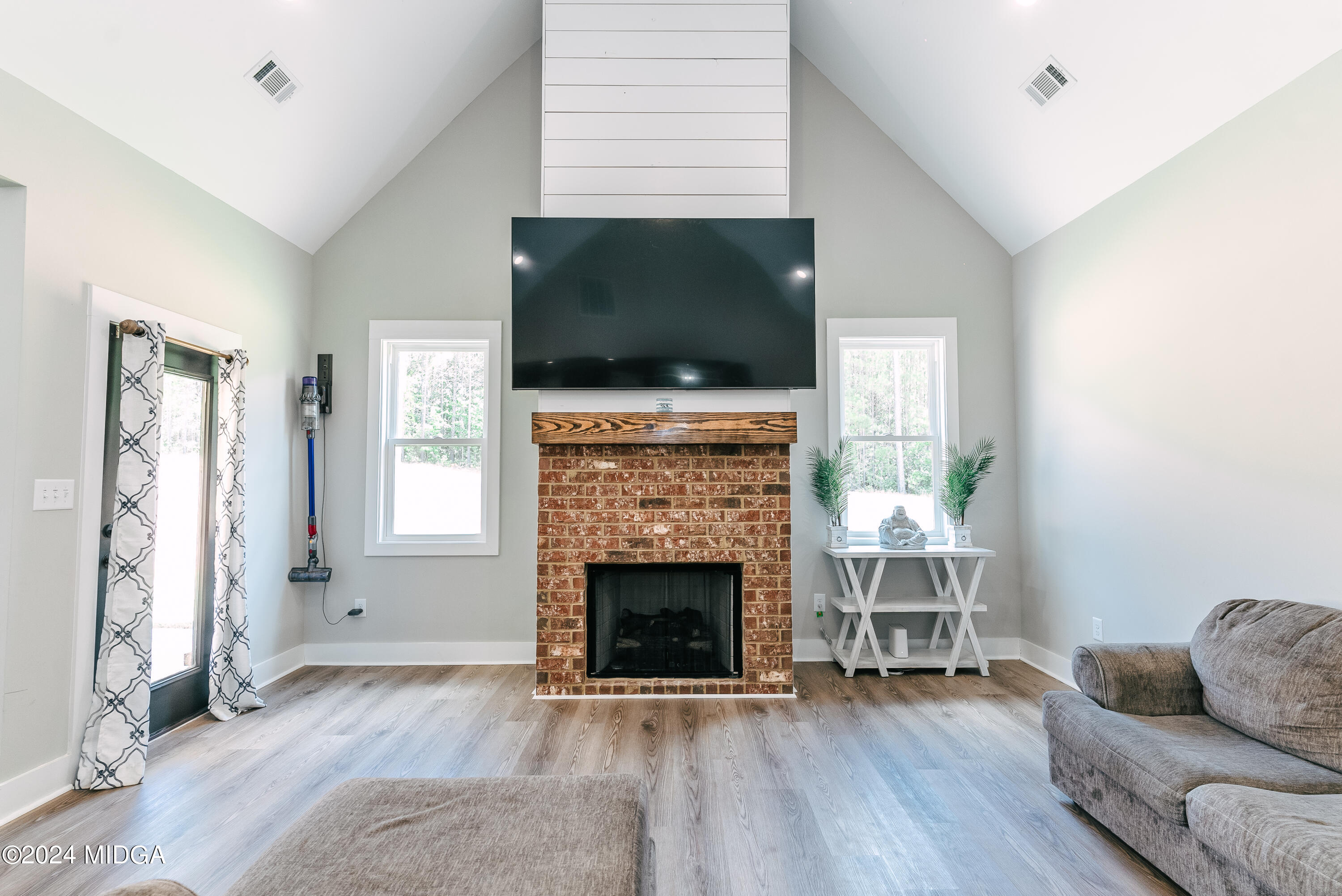 1190 Josey Road Forsyth, GA 31029 - Photo 12 of 25 a living room with furniture a flat screen tv and a fireplace