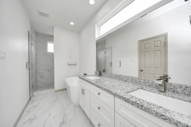 a spacious bathroom with a granite countertop sink and a mirror
