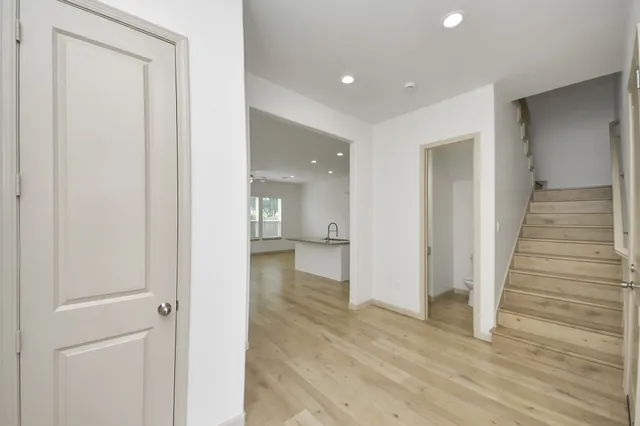 a view of a hallway with wooden floor and closet