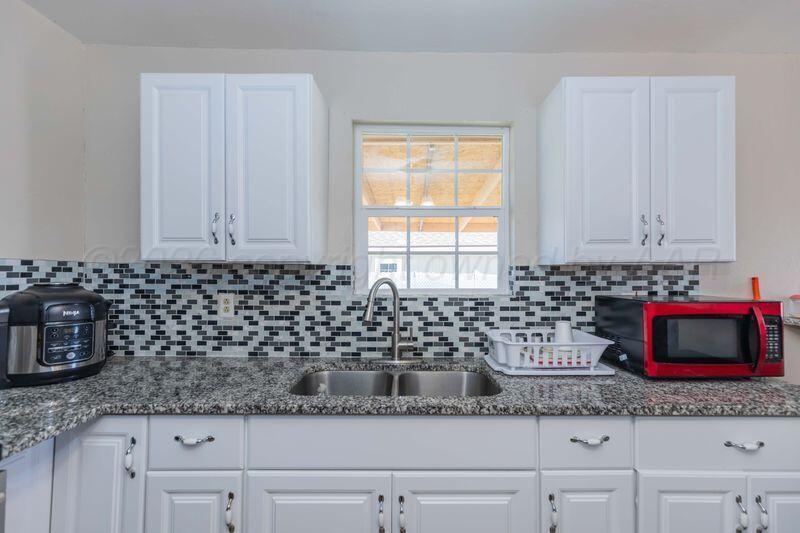 2106 Southwest 1st Avenue Amarillo, TX 79106 - Photo 2 of 17 a kitchen with granite countertop white cabinets and a sink