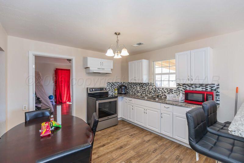 2106 Southwest 1st Avenue Amarillo, TX 79106 - Photo 4 of 17 a kitchen that has a lot of cabinets a stove and a window