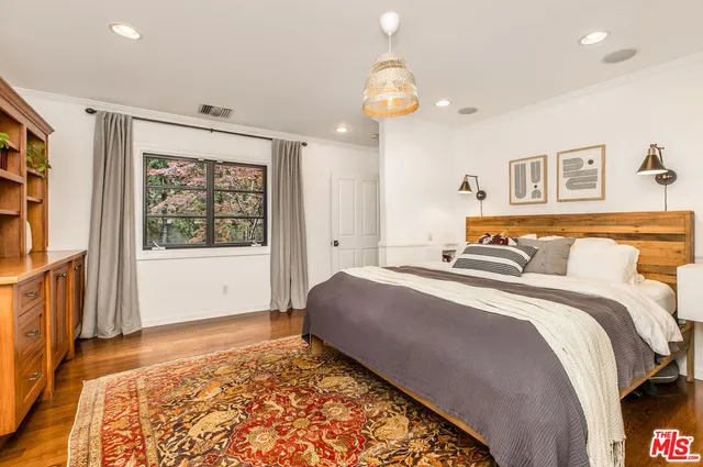 a bedroom with bed and wooden floor