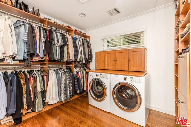 a view of walk in closet with clothes and shoes
