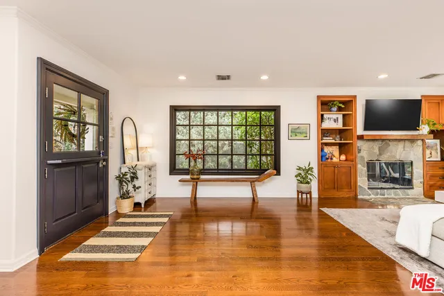 a living room with fireplace furniture and a large window