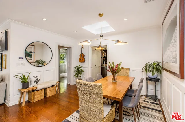 a dining room with furniture a chandelier and wooden floor