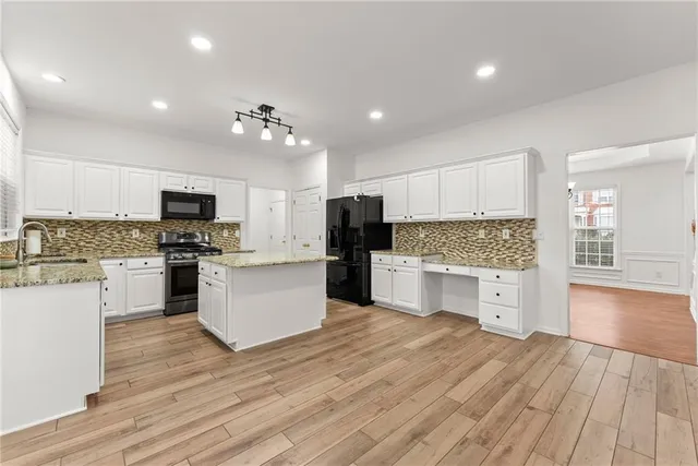 a kitchen with white cabinets and stainless steel appliances