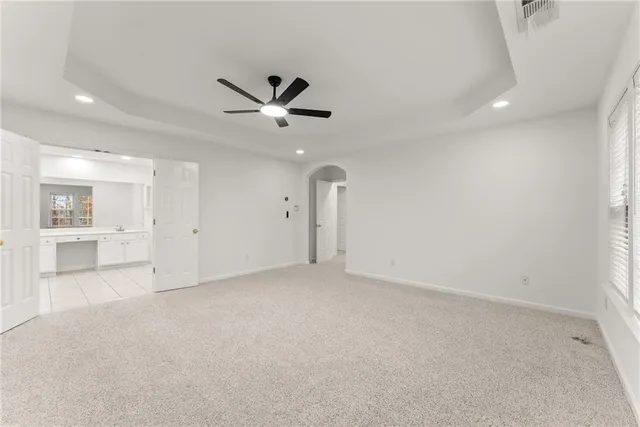 an empty room with a ceiling fan and a window