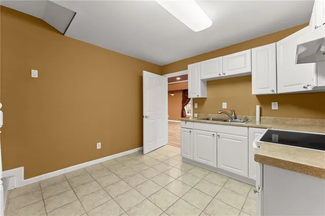 a kitchen with a stove sink and cabinets