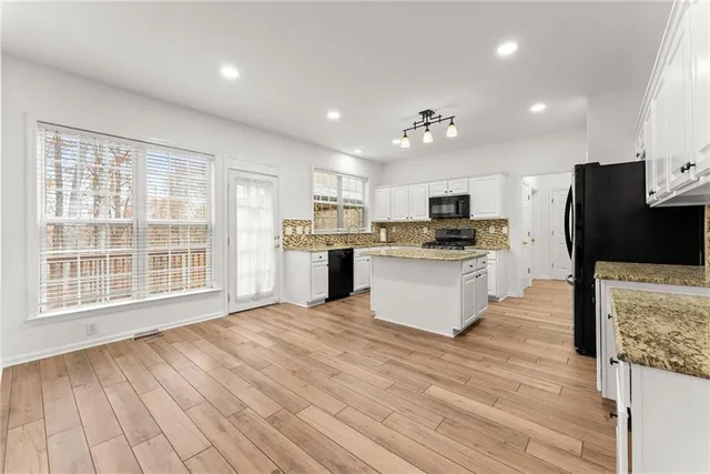 a large kitchen with cabinets wooden floor and stainless steel appliances